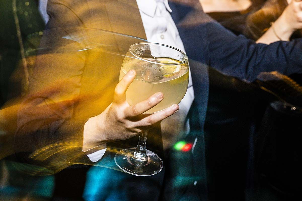 Una persona sostiene una copa de vino en su mano.