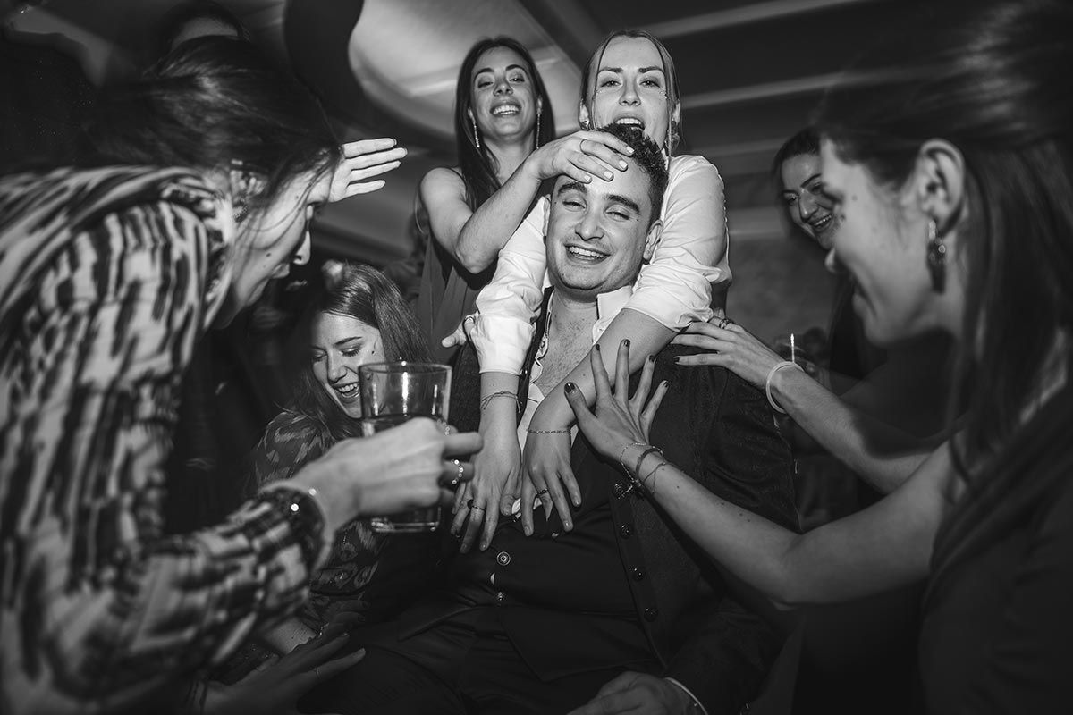 Un grupo de personas están bailando en una fiesta en una foto en blanco y negro.