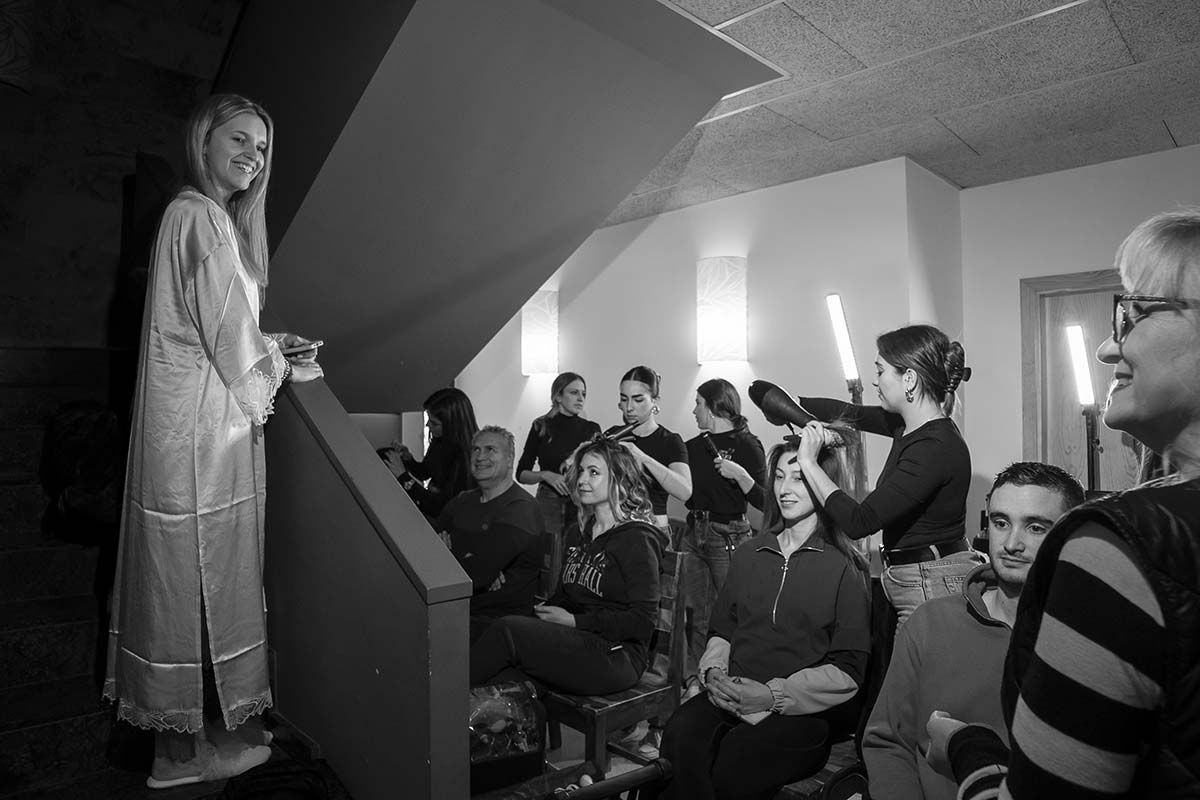 Una fotografía en blanco y negro de una mujer parada frente a un grupo de personas.