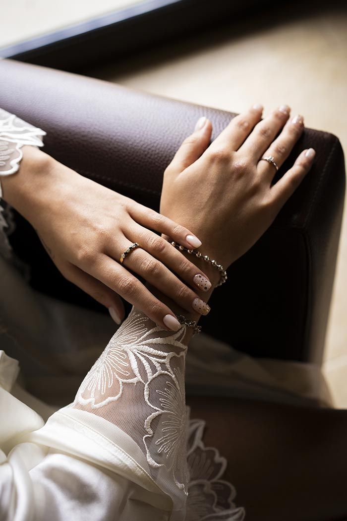 Un primer plano de las manos de una mujer con anillos de boda en ellas.
