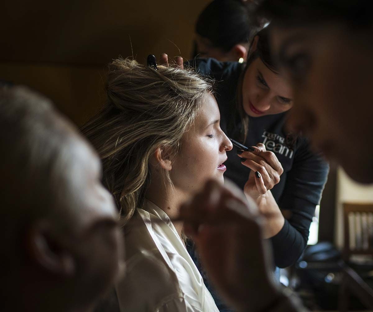 Una mujer se está maquillando con un maquillador.