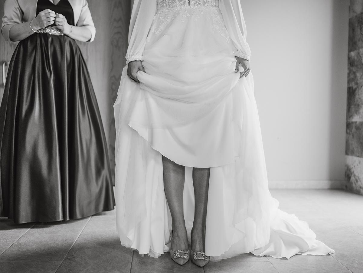 Una mujer con un vestido de novia está de pie junto a otra mujer con una falda larga.