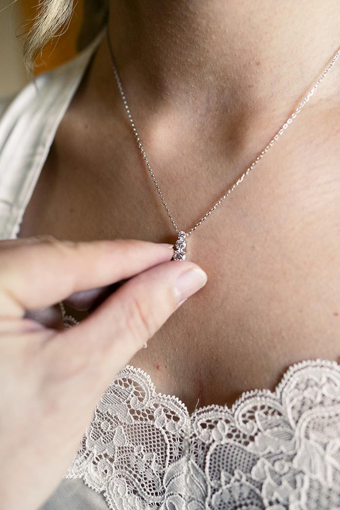 Una mujer se pone un collar en el cuello.