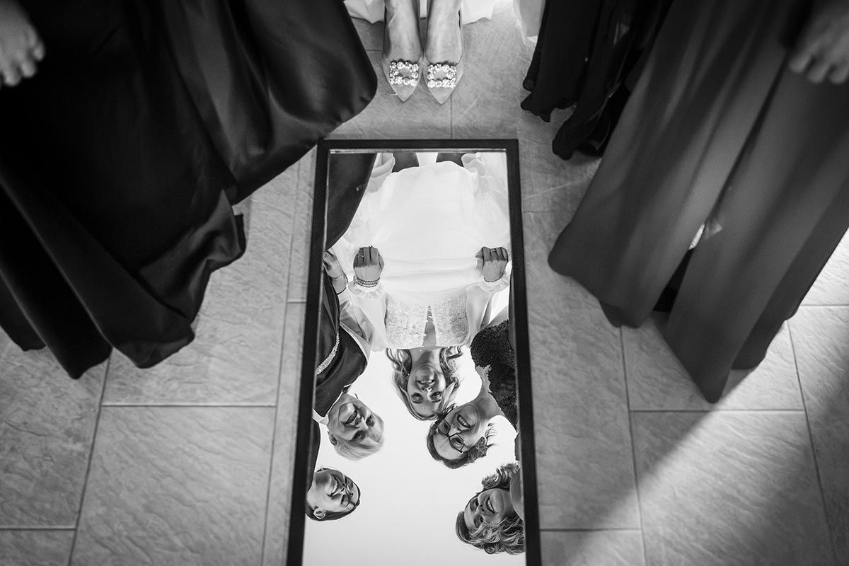 Una fotografía en blanco y negro de un grupo de personas de pie alrededor de un espejo.