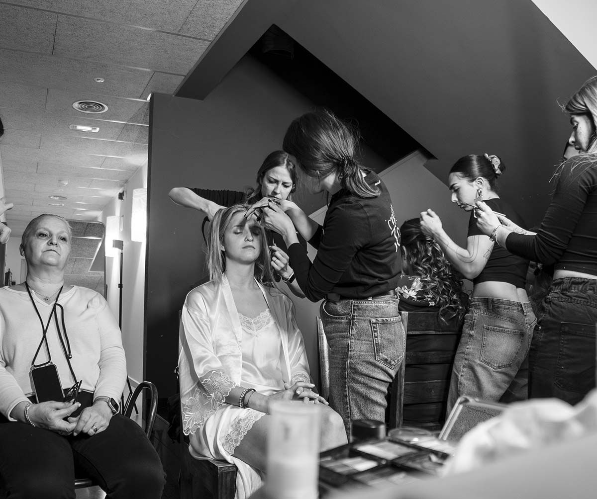 Una fotografía en blanco y negro de un grupo de mujeres preparándose para una boda.