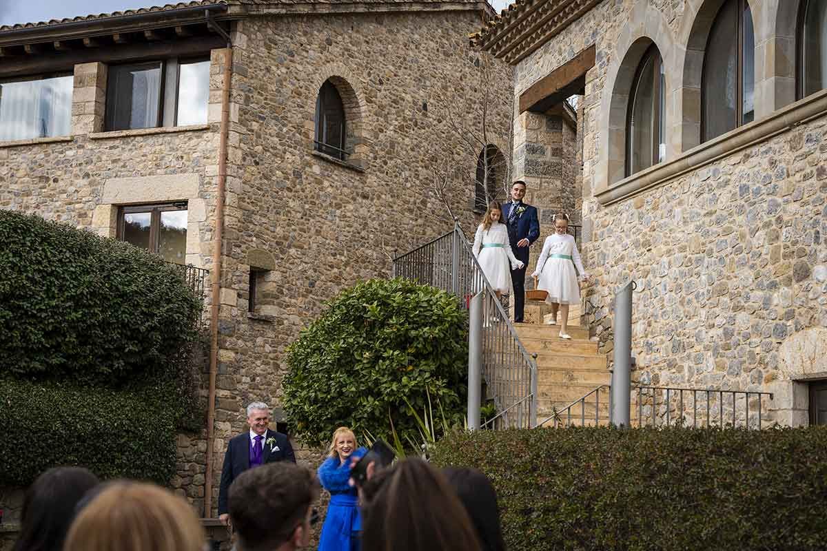 Una novia y un novio bajan las escaleras de un edificio de piedra.