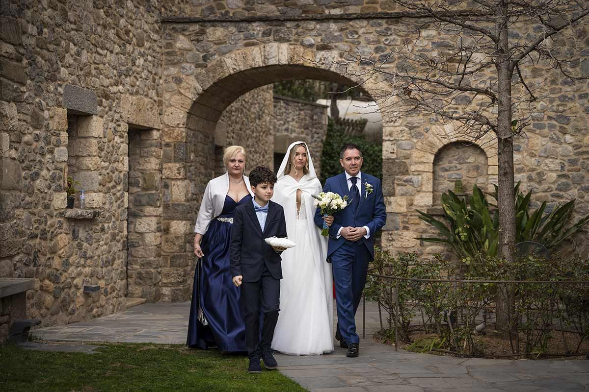 Una novia y un novio caminan por el pasillo con sus hijos.