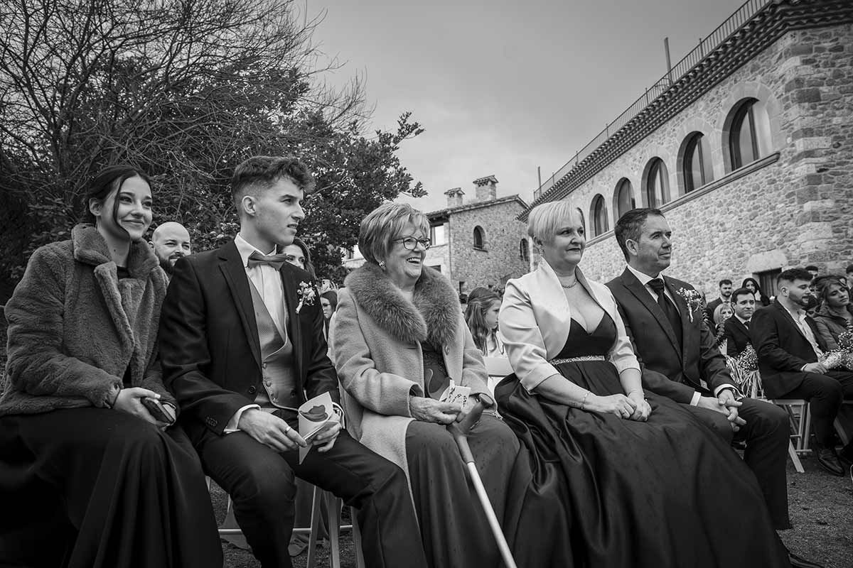 Una fotografía en blanco y negro de un grupo de personas sentadas frente a un edificio.