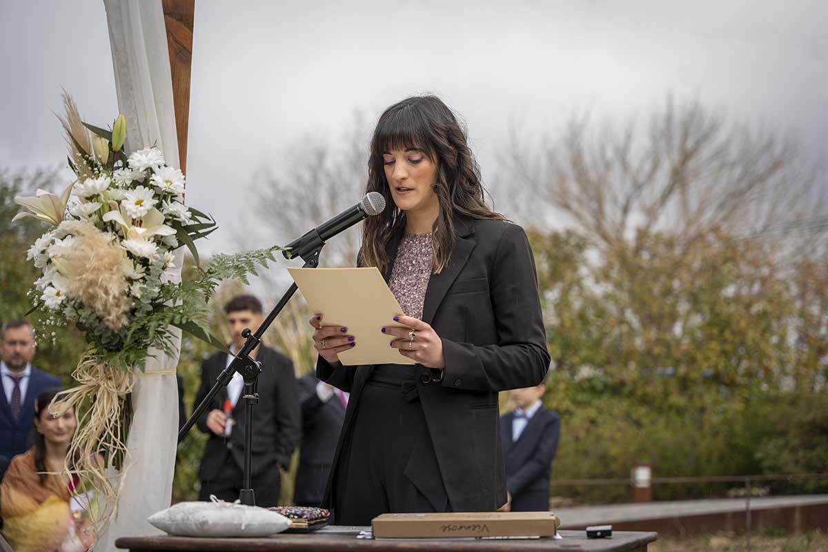 Una mujer está parada frente a un micrófono sosteniendo un trozo de papel.