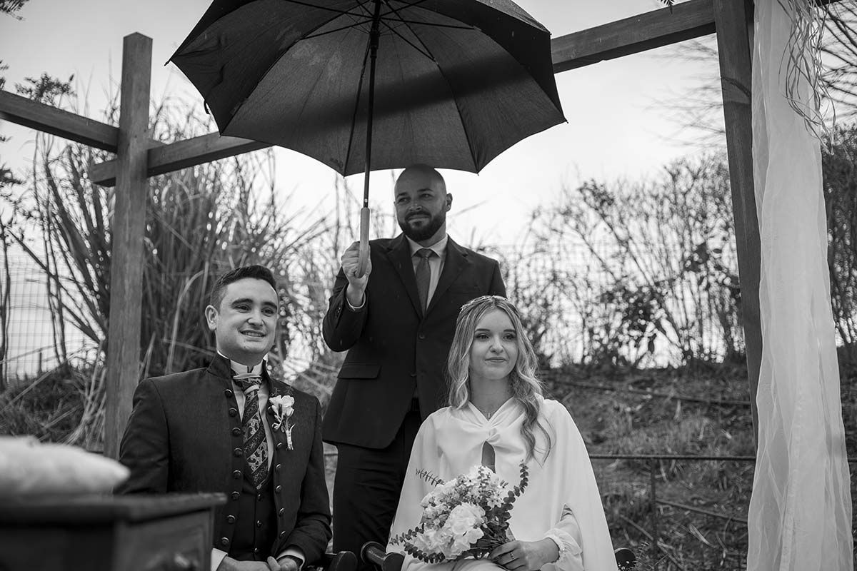 Una fotografía en blanco y negro de una novia y un novio bajo un paraguas.