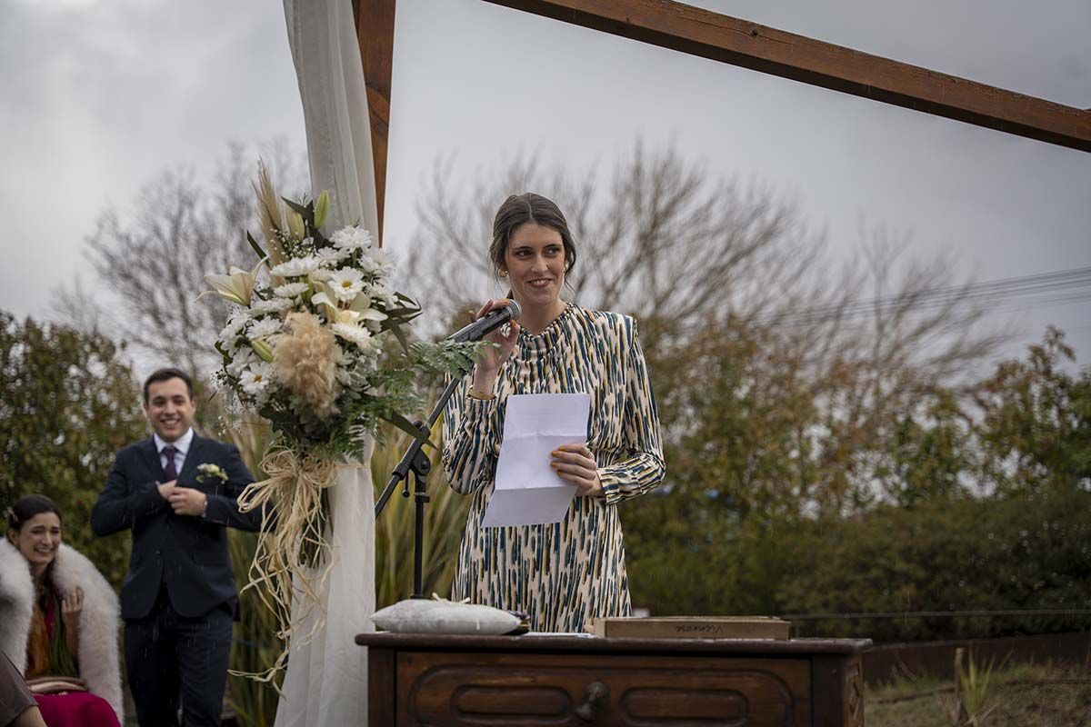 Una mujer está parada frente a un micrófono sosteniendo un trozo de papel.