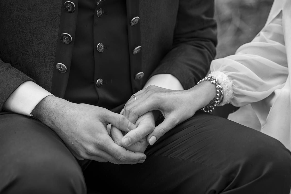 Un hombre y una mujer se toman de la mano en una fotografía en blanco y negro.