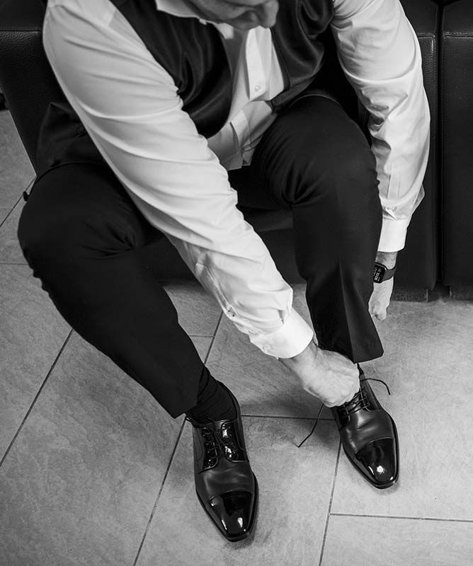 Una fotografía en blanco y negro de un hombre atándose los zapatos.