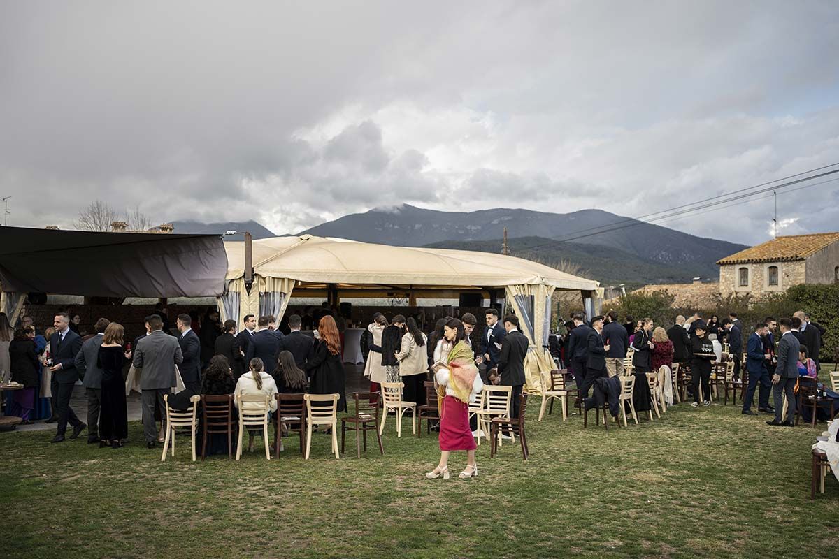 Un grupo de personas está de pie en un campo frente a una tienda de campaña.