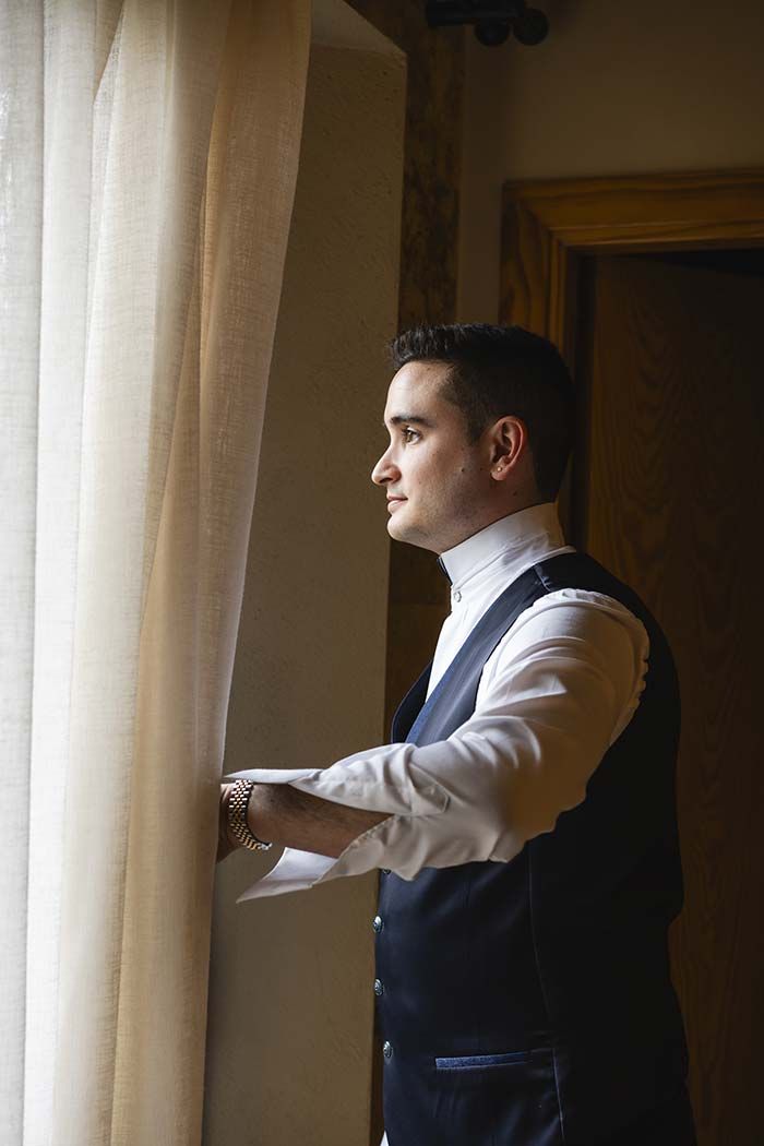 Un hombre con traje mira por una ventana.