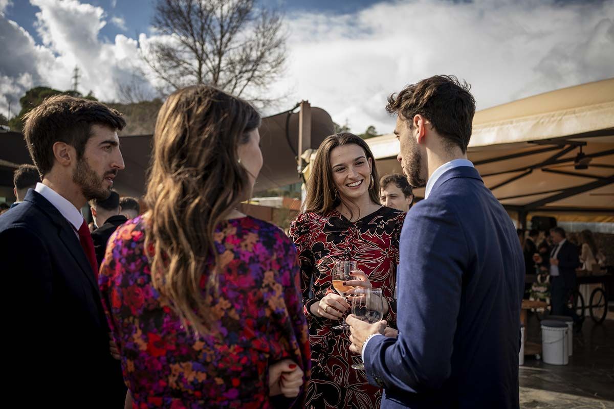 Un grupo de personas están de pie hablando entre sí en una fiesta.