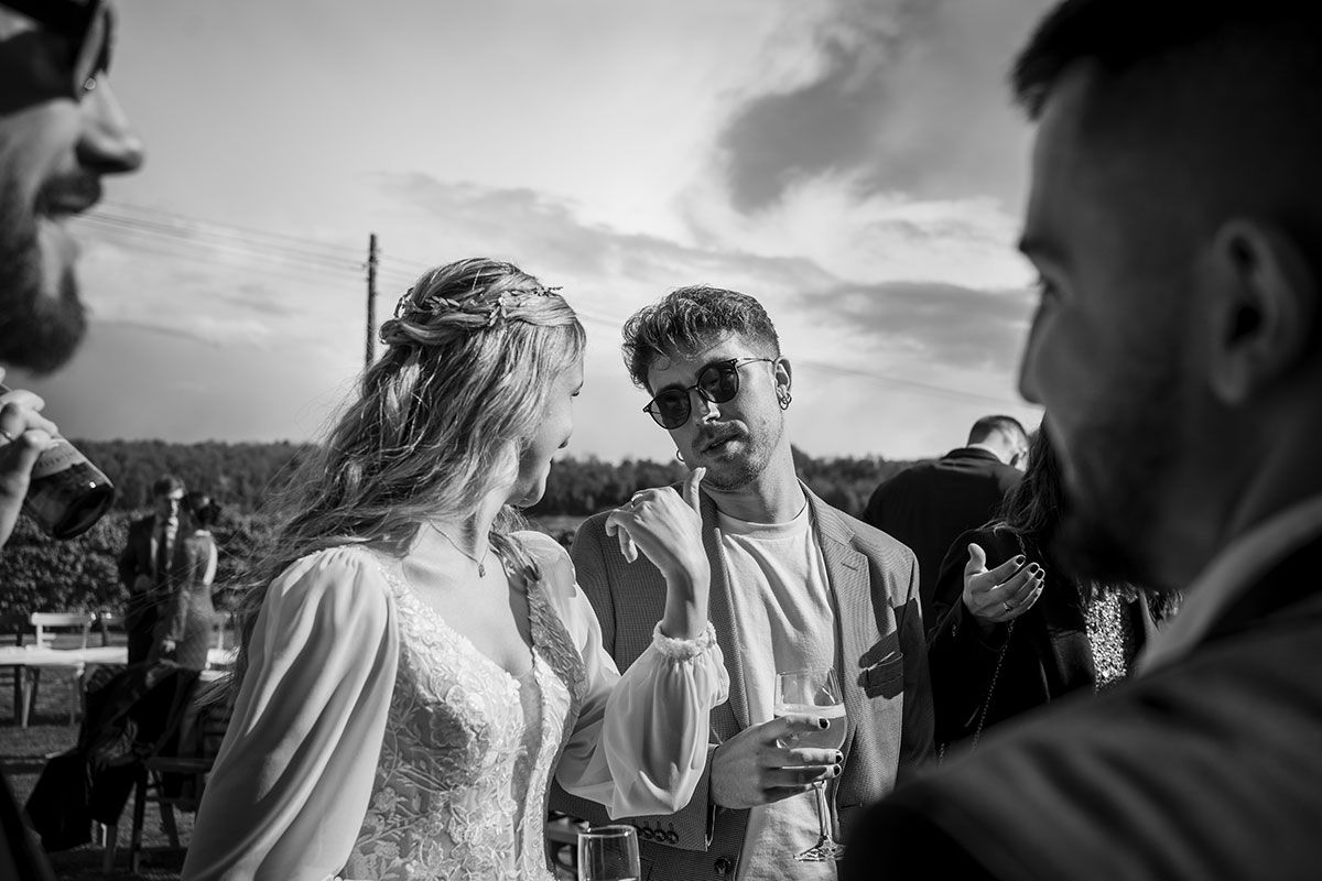 Una novia y un novio están de pie uno al lado del otro en una foto en blanco y negro.