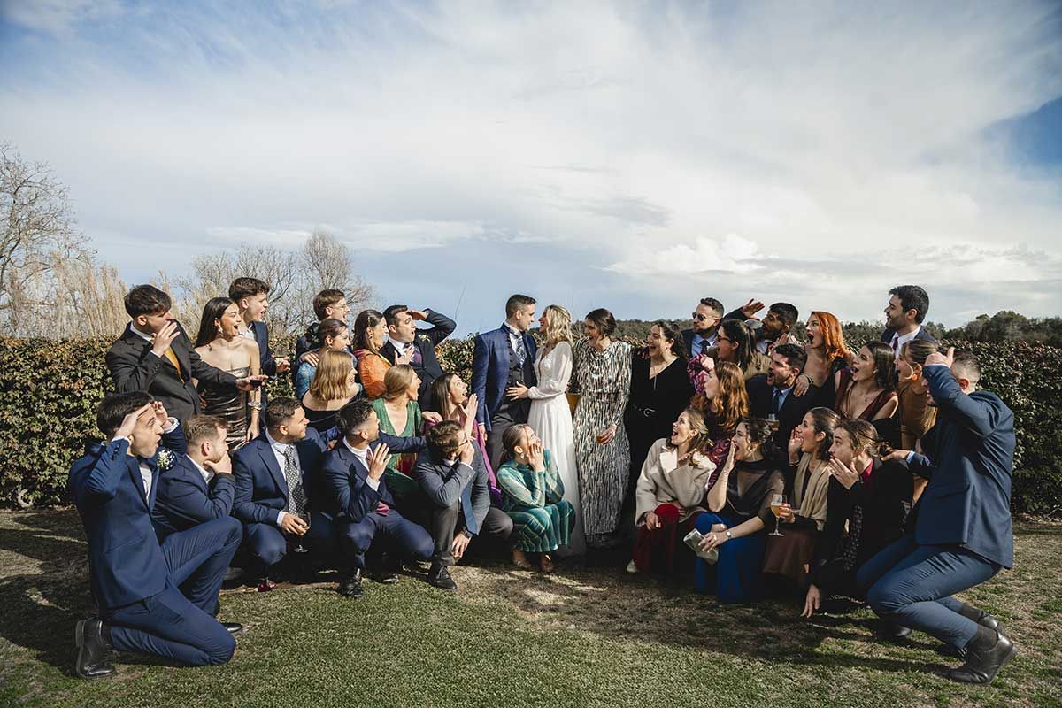 Un grupo grande de personas posa para una fotografía en una boda.
