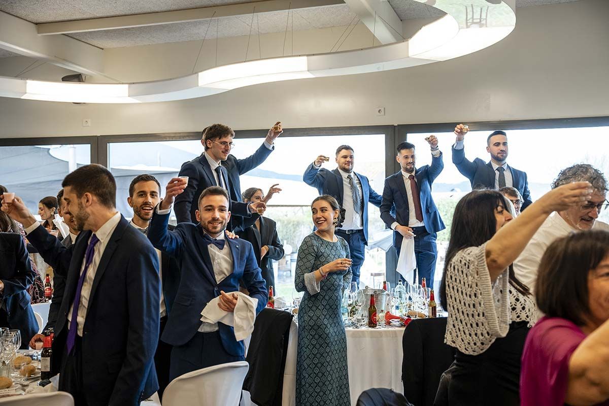 Un grupo de personas está de pie en una habitación con los brazos en el aire.