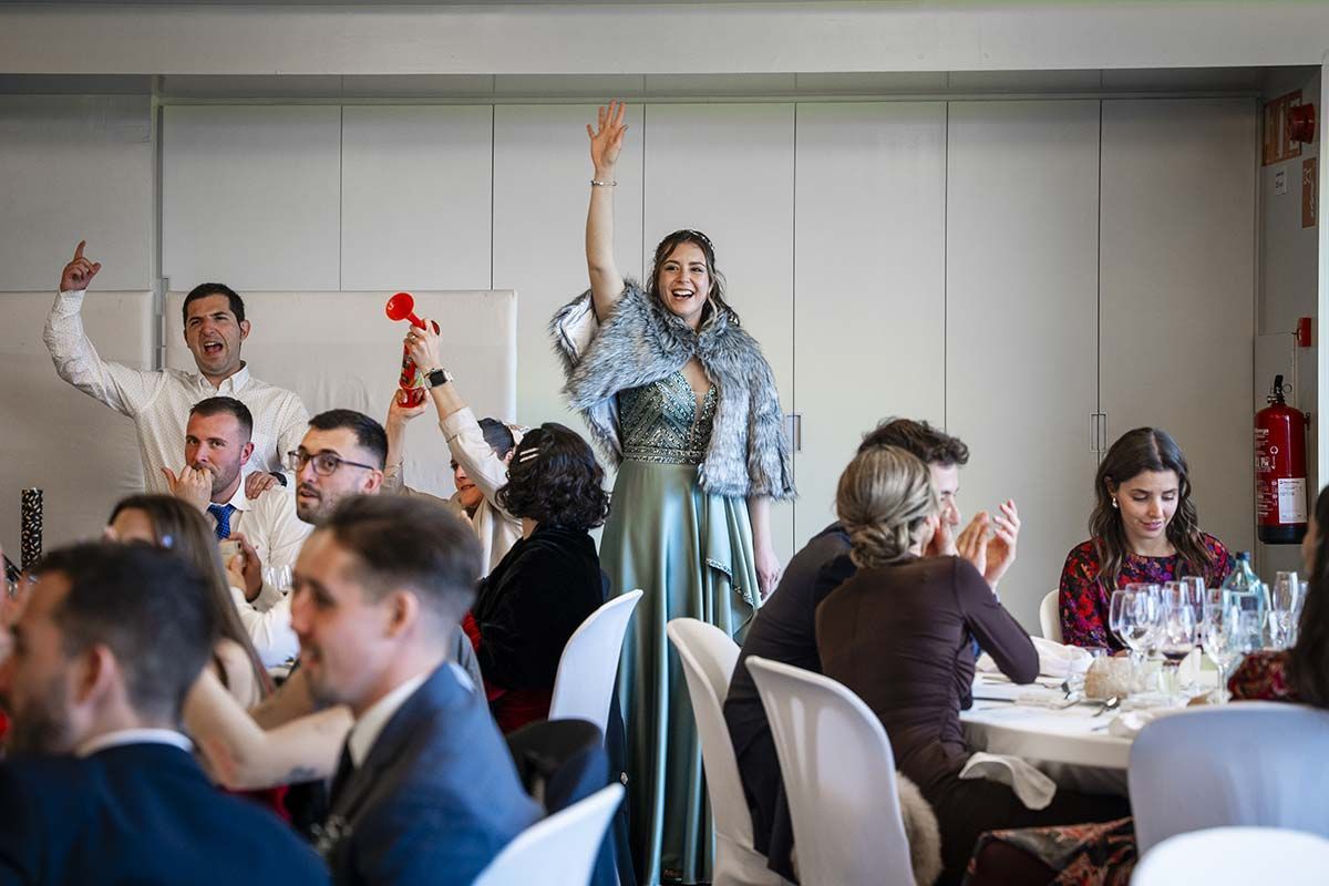 Una mujer está parada frente a una multitud de personas en una recepción de boda.