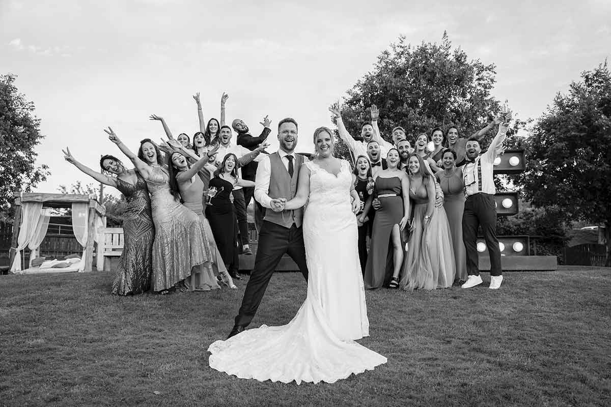 Una novia y un novio posan para una fotografía con su fiesta nupcial.