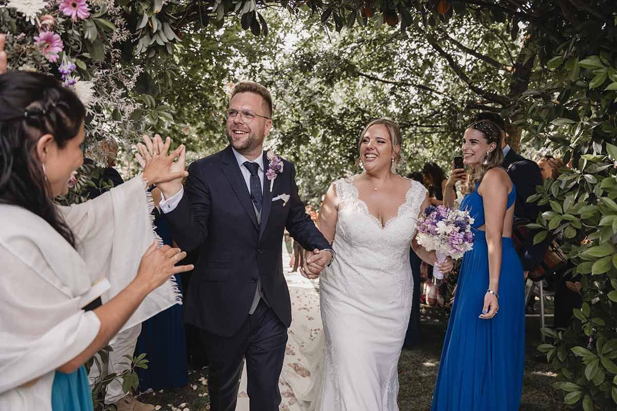 Una novia y un novio caminan por el pasillo con su cortejo nupcial.