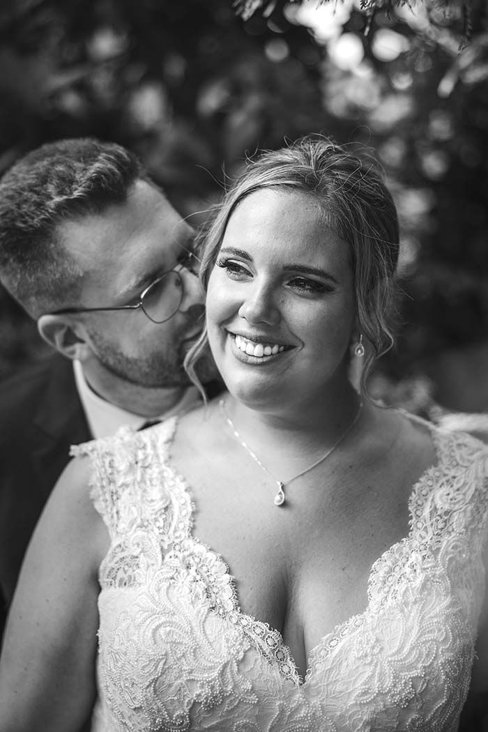 Un hombre besa a una mujer en la mejilla en una foto en blanco y negro.