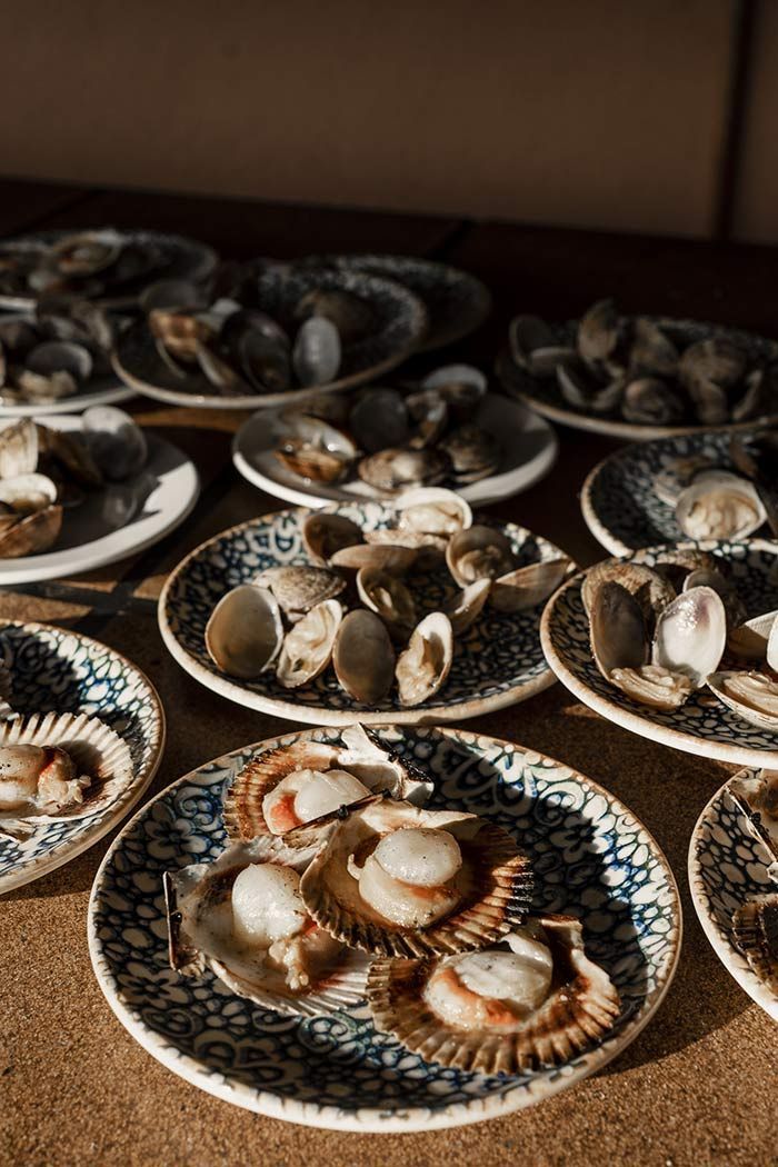 Hay muchos platos de mariscos en la mesa.