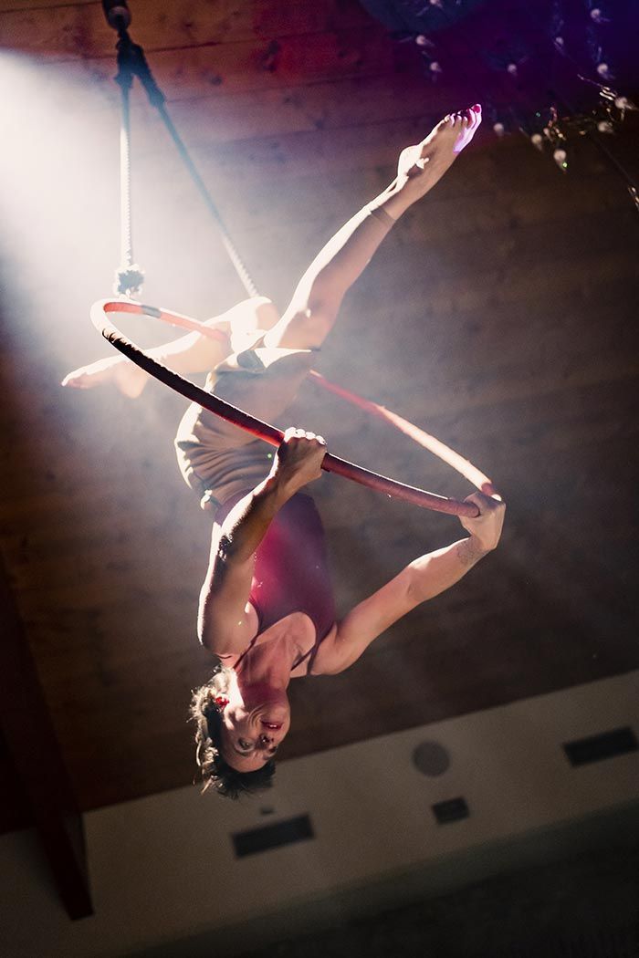 Una mujer está realizando acrobacias aéreas en un aro.