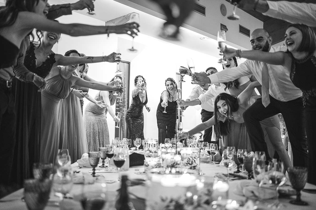 Un grupo de personas están de pie alrededor de una mesa con copas de vino.