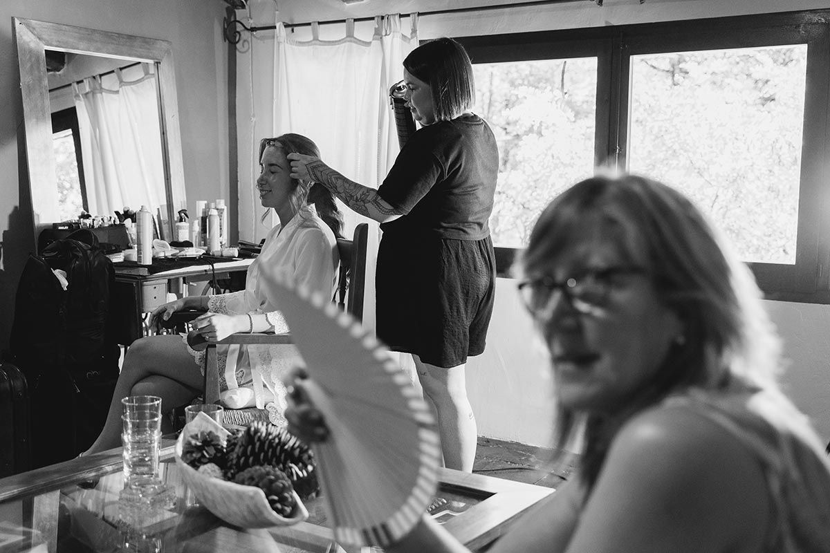 En una foto en blanco y negro, una mujer se está peinando en la peluquería.