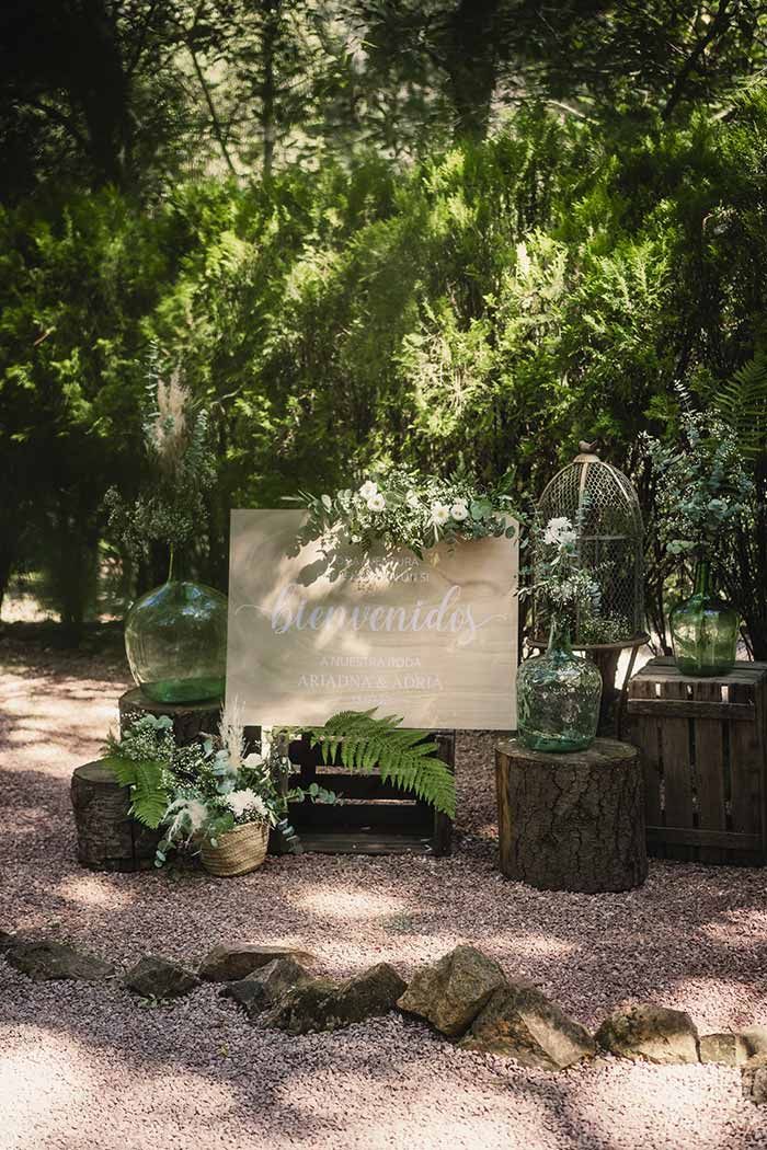 Un cartel de madera se encuentra en medio de un bosque.