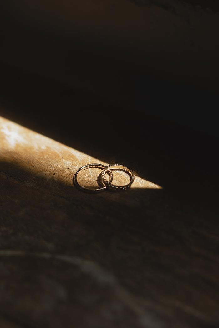 Un par de anillos de boda colocados encima de un palo de madera.