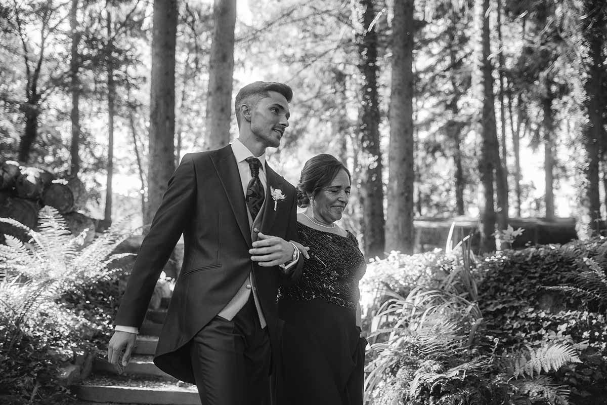 Un hombre con traje y corbata camina con una mujer en una foto en blanco y negro.
