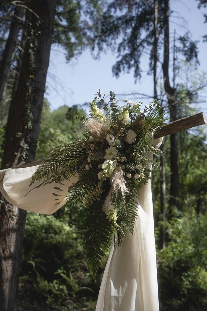 Un vestido blanco cuelga de un árbol en el bosque.