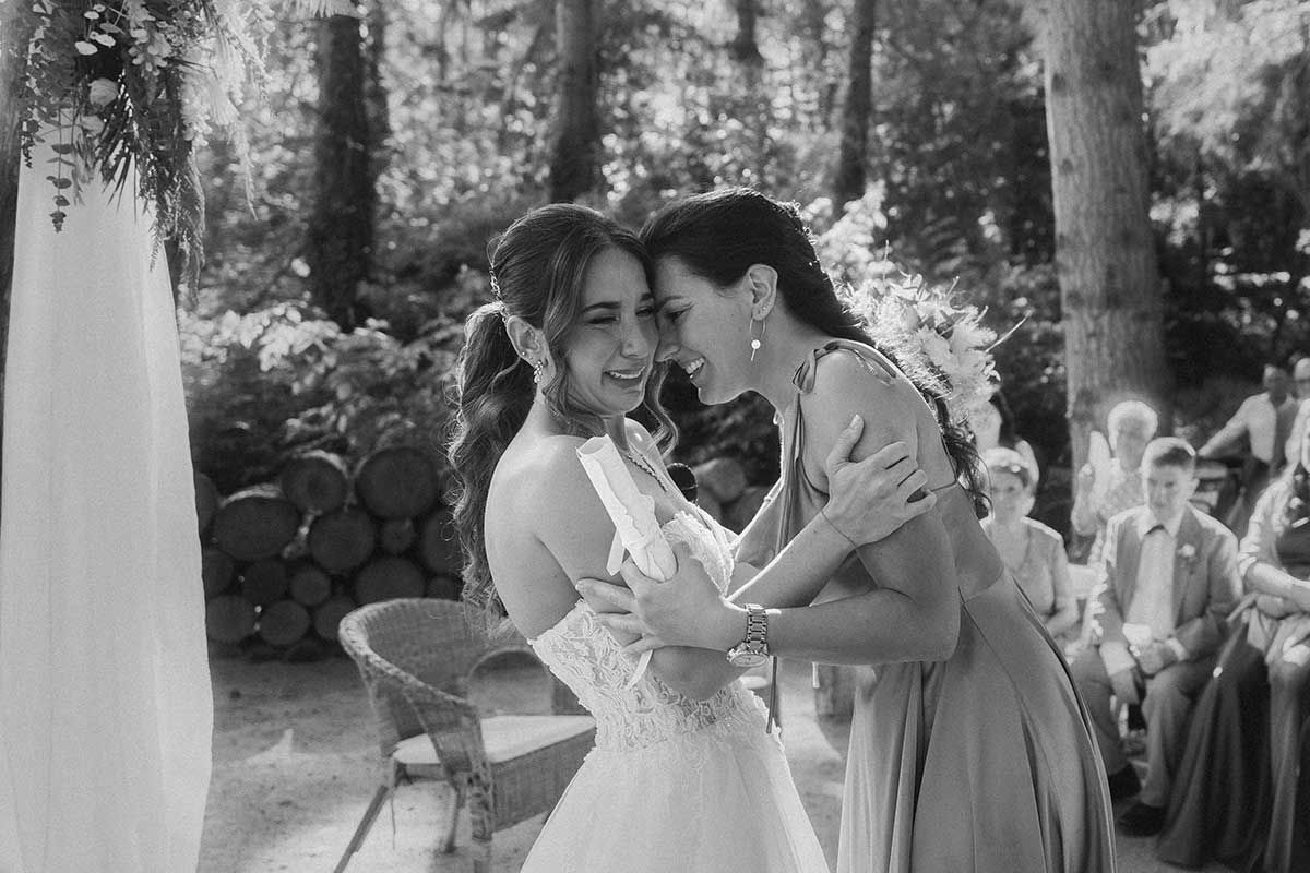 Una novia y su madre se abrazan en una foto en blanco y negro.