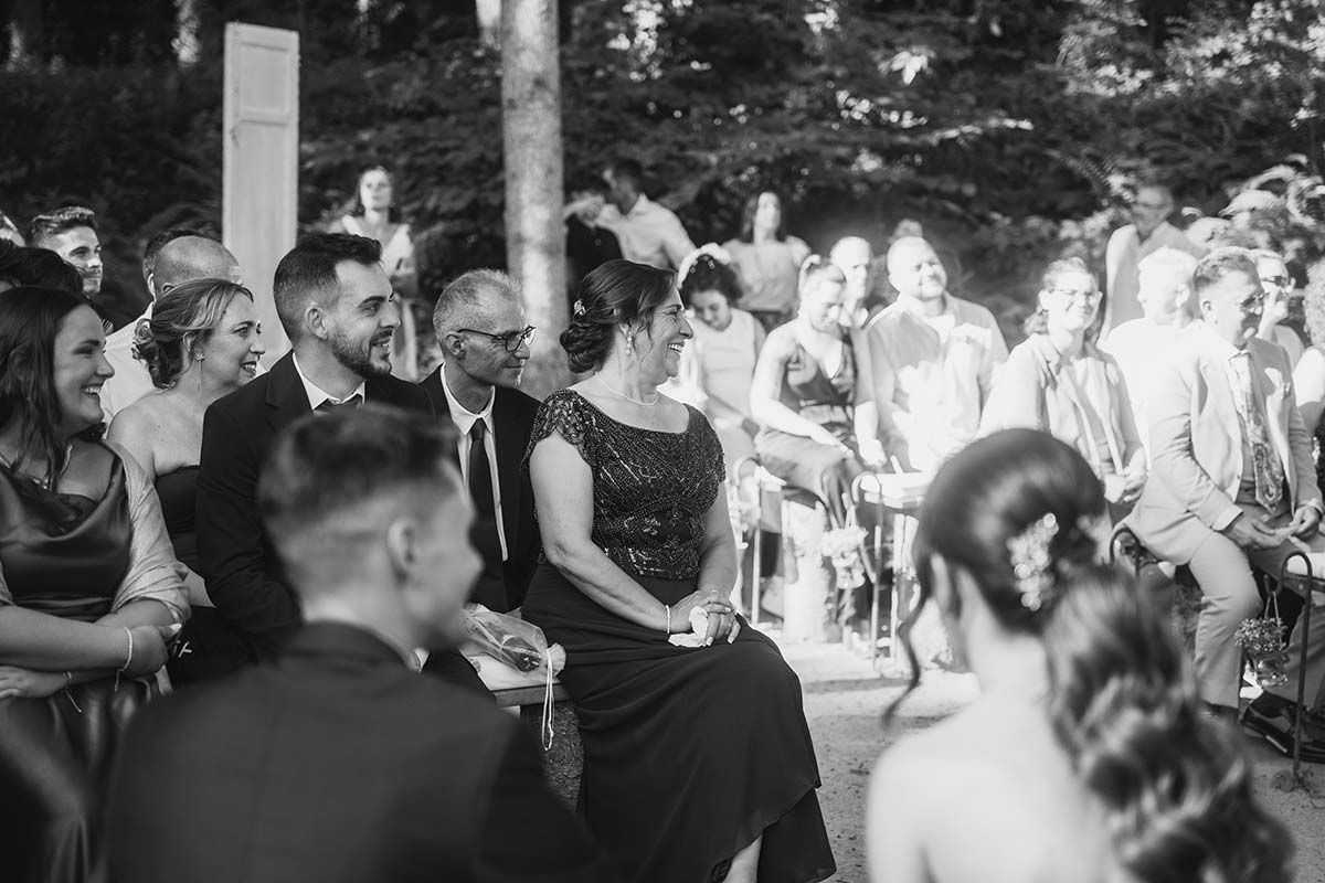 Una fotografía en blanco y negro de un grupo de personas sentadas en una ceremonia de boda.