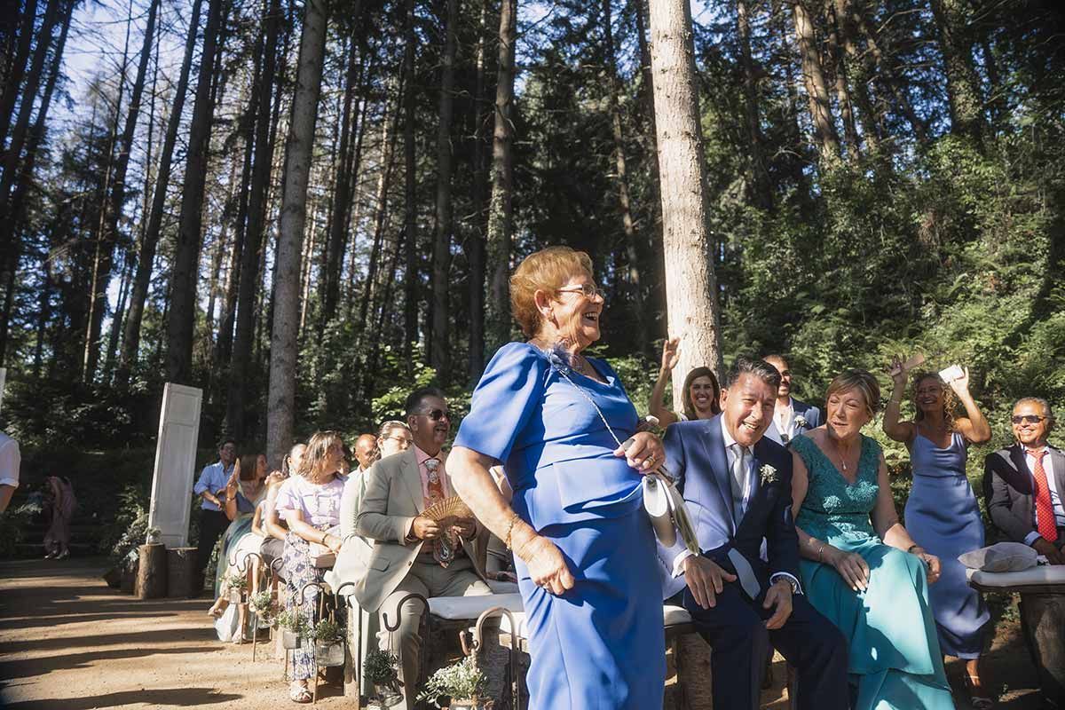 Una mujer con un vestido azul está bailando frente a una multitud de personas en una boda.