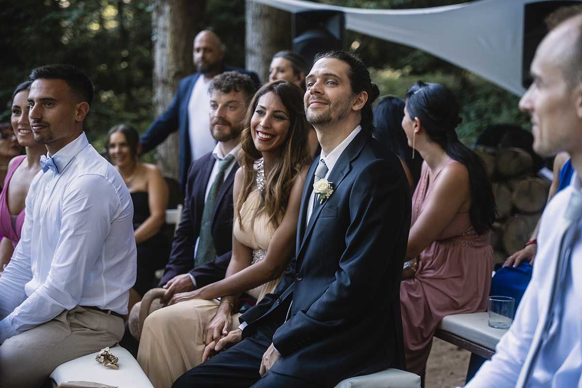 Un grupo de personas están sentadas en fila en una boda.