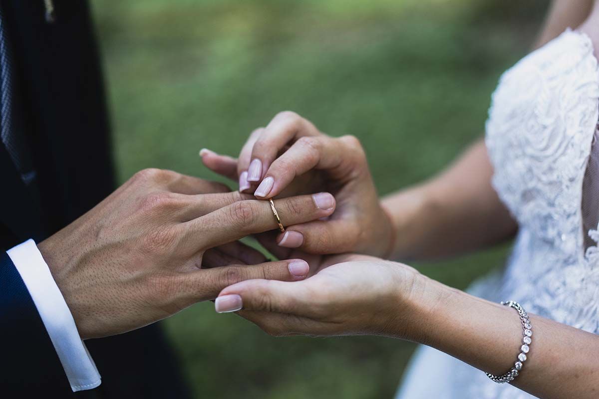Un hombre está poniendo un anillo de bodas en el dedo de una mujer.