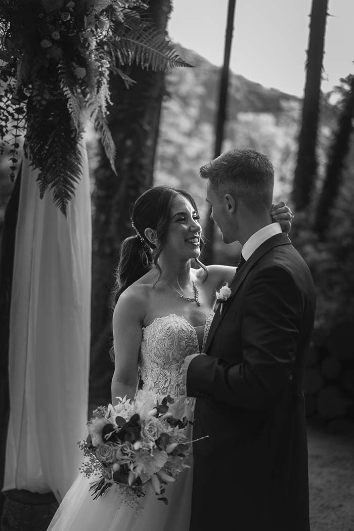 Una fotografía en blanco y negro de una novia y un novio mirándose.