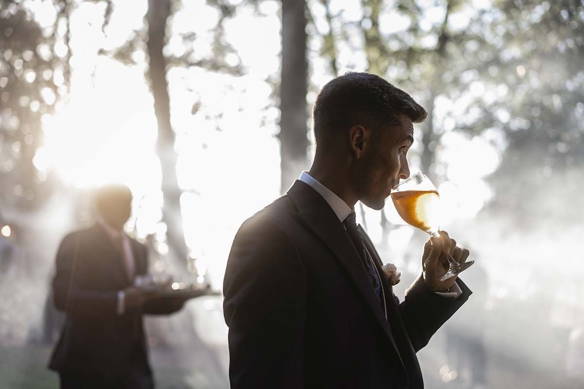 Un hombre con traje está bebiendo una copa de vino.