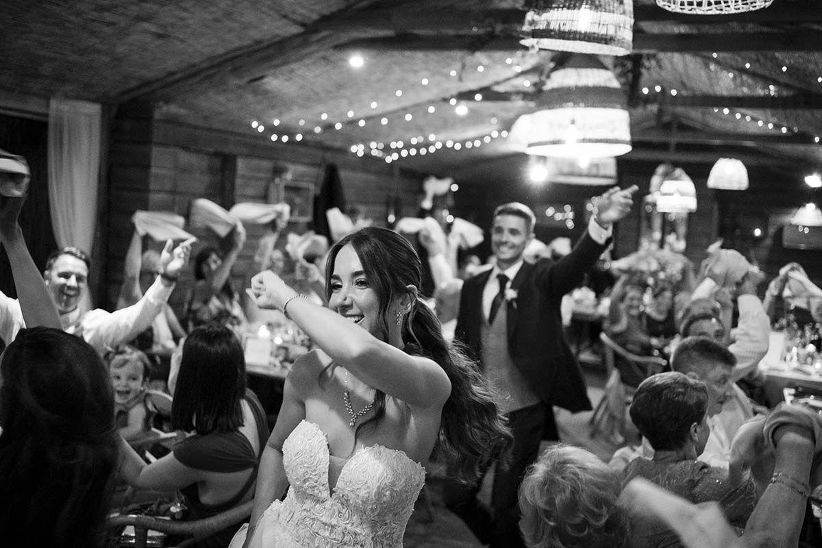 Una fotografía en blanco y negro de una novia y un novio bailando en una recepción de boda.