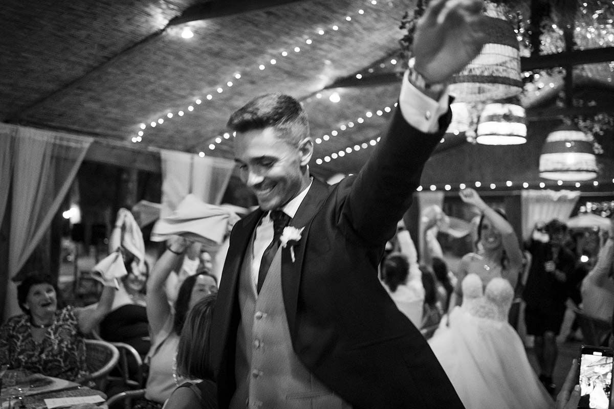 Una fotografía en blanco y negro de una novia y un novio bailando en una recepción de boda.