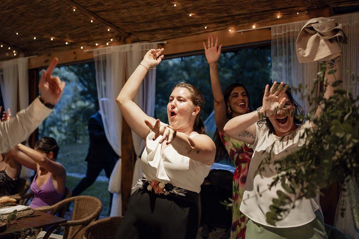 Un grupo de personas está bailando en una habitación con los brazos en el aire.