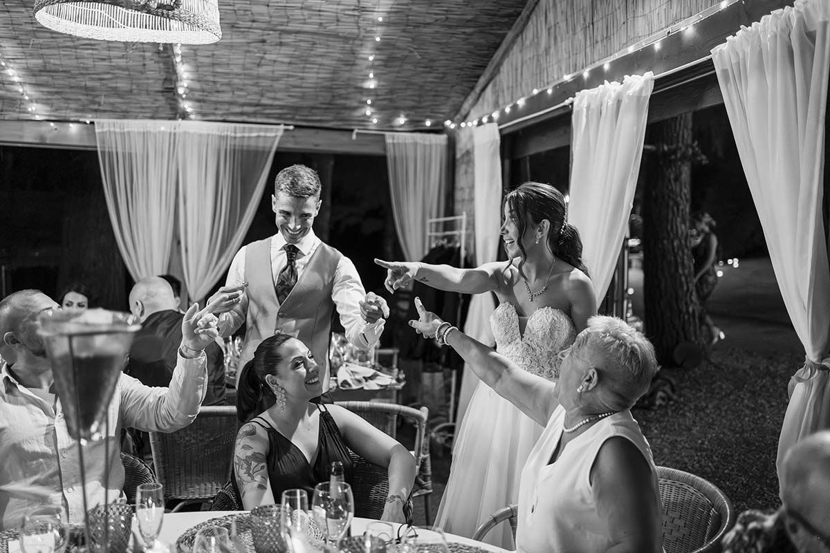Un grupo de personas está sentada en una mesa en una recepción de boda.