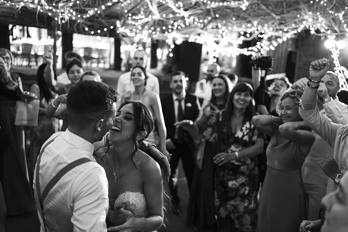 Una fotografía en blanco y negro de una novia y un novio bailando en una recepción de boda.