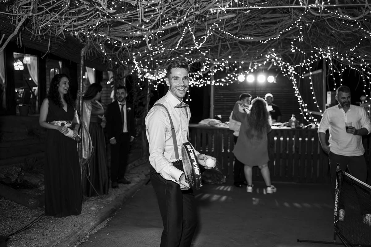 Una fotografía en blanco y negro de un hombre tocando una pandereta en la recepción de una boda.