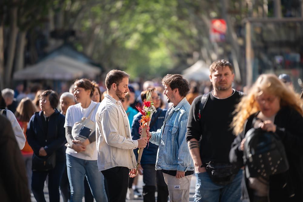 Un hombre sostiene un ramo de flores delante de una multitud de personas.