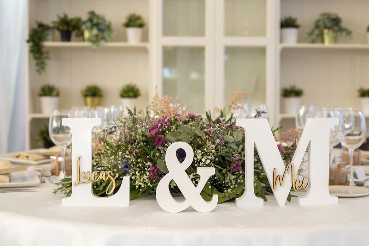 Las letras l y m están sobre una mesa con flores.